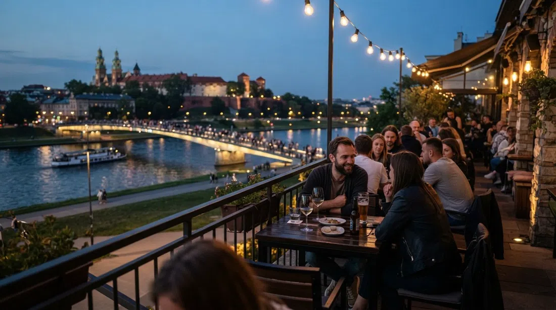 Terraza de Drukarnia Jazz Club en Nadwiślańska 1 frente al Vístula al atardecer, con el río y las luces del puente a la vista